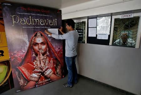 A worker tapes a message in support of the release of the upcoming Bollywood film "Padmavati" on its poster at a ticket selling counter in a cinema hall in Kolkata, India, November 28, 2017. REUTERS/Rupak De Chowdhuri