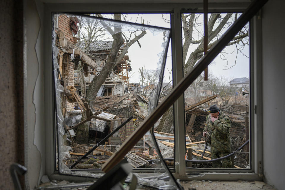 Andrey Goncharuk, 68, a member of territorial defense wipes his face in the back yard of a house that was damaged by a Russian airstrike in Gorenka Wednesday. (AP Photo/Vadim Ghirda)