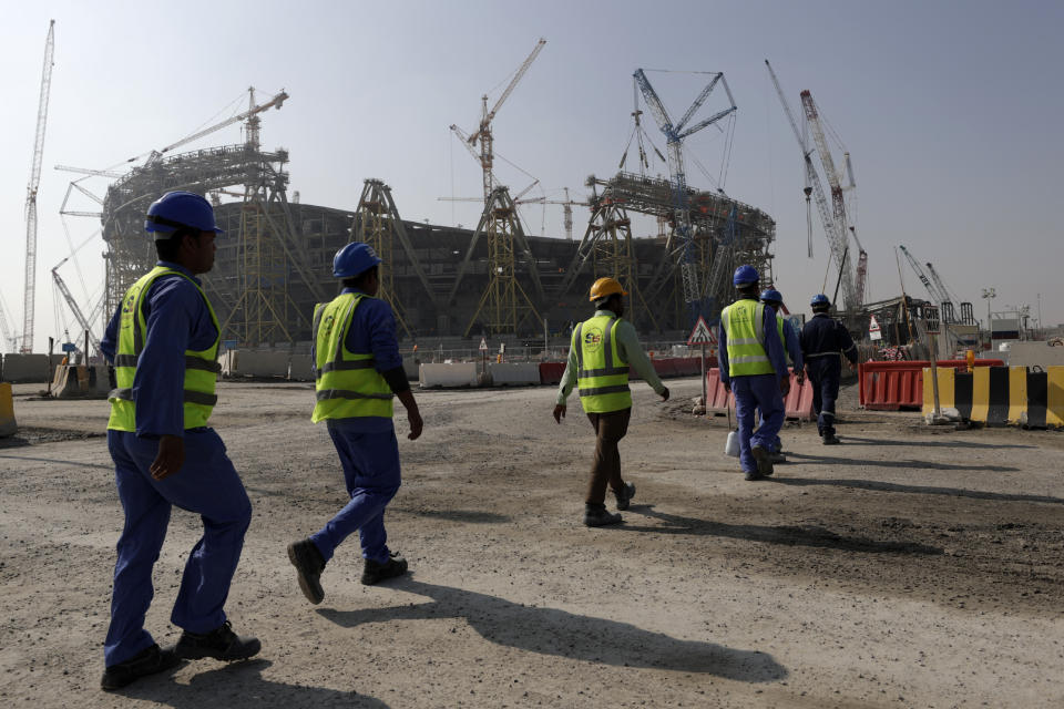 Workers walk to the Lusail Stadium, one of the 2022 World Cup stadiums, in Lusail, Qatar, Dec. 20, 2019. A former CIA officer who spied on Qatar’s rivals to help the tiny Arab country land this year’s World Cup is now under FBI scrutiny and newly obtained documents show he offered clandestine services that went beyond soccer to try to influence U.S. policy, an Associated Press investigation found. (AP Photo/Hassan Ammar)