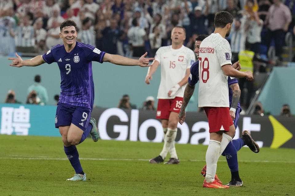 Argentina's Julian Alvarez, left, celebrates after scoring a goal during the World Cup group C soccer match between Poland and Argentina at the Stadium 974 in Doha, Qatar, Wednesday, Nov. 30, 2022. (AP Photo/Natacha Pisarenko)