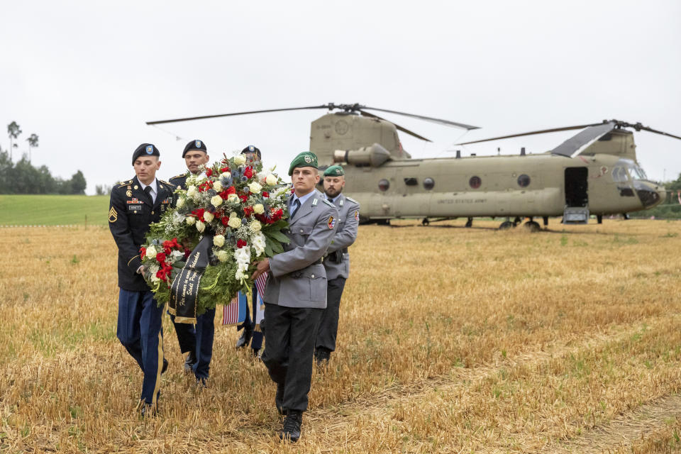 U.S. and German soldiers pick up wreaths from a Chinook transport helicopter during a commemoration of a helicopter crash in Pegnitz, Germany, Wednesday, Aug. 18, 2021. On Aug. 18, 1971, a U.S. Army Chinook helicopter crashed near Pegnitz. 37 soldiers were killed. It is the worst accident of the US Army since the Second World War. (Daniel Karmann/dpa via AP)