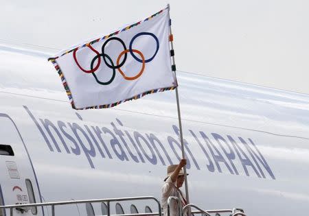 La gobernadora de Tokio, Yuriko Koike, ondea la bandera Olímpica mientras sale de un avión en el aeropuerto de Haneda, en Tokio, Japón. 24 de agosto de 2016. El gobernador de Tokio, Yuriko Koike, hizo un llamado a todos los sectores de Japón a trabajar juntos para organizar unos exitosos Juegos Olímpicos en 2020, tras llegar el miércoles al país con la bandera olímpica proveniente de Brasil. REUTERS/Kim Kyung-Hoon