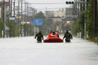Japan Self Defense Force members rescue residents on a rubber boat on a flooded road hit by heavy rain in Omuta, Fukuoka prefecture, southern Japan Tuesday, July 7, 2020. Rescue operations continued and rain threatened wider areas of the main island of Kyushu. (Juntaro Yokoyama/Kyodo News via AP)
