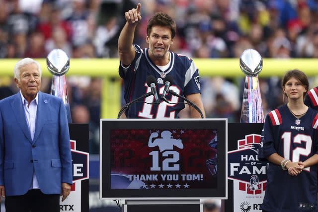 <p>Kevin Sabitus/Getty Images</p> New England Patriots owner Robert Kraft speaks while former New England Patriots quarterback Tom Brady reacts while Brady's children, Vivian, Benjamin, and Jack, look on during a ceremony honoring Brady at halftime of New England's game against the Philadelphia Eagles