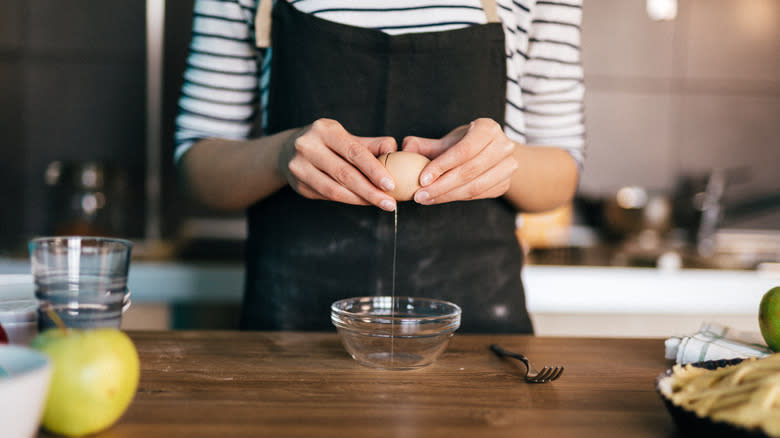 Woman cracking open an egg