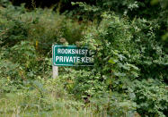 A sign marks the Rooksnest estate as private property near Lambourn, England, Tuesday, Aug. 6, 2019. The haziness surrounding the estate hints at one of the challenges for government lawyers as they eye a possible settlement with Purdue Pharma L.P. and its owners, the Sackler family, for their alleged role in flooding communities with prescription painkillers. (AP Photo/Frank Augstein)