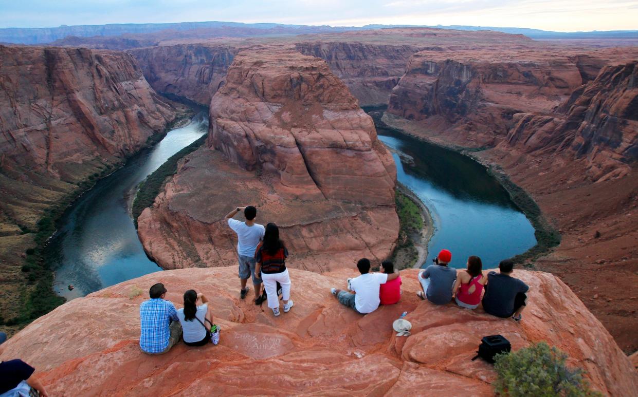 FILE - In this Sept. 9, 2011 file photo visitors view the dramatic bend in the Colorado River at the popular Horseshoe Bend in Glen Canyon National Recreation Area, in Page, Ariz. Some 40 million people in Arizona, California, Colorado, Nevada, New Mexico, Utah and Wyoming draw from the Colorado River and its tributaries.
