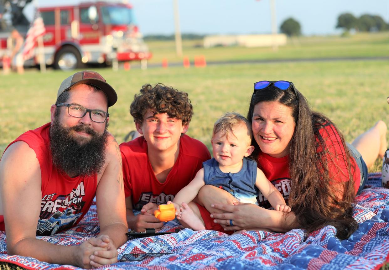 Jaycee Dennison, Terry Dennison, Megan Dennison, Chasity Baker relax on a blanket at the Firefighters Freedom Festival hosted by the Madison County Fire Department at McKellar Sipes Regional Airport on July 3.