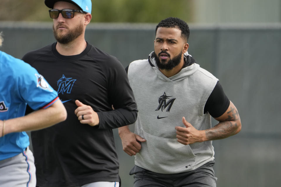 Miami Marlins pitcher Sandy Alcantara, right, participates a spring training baseball workout Friday, Feb. 16, 2024, in Jupiter, Fla. Alcantara underwent Tommy John surgery at the end of last season. (AP Photo/Jeff Roberson)