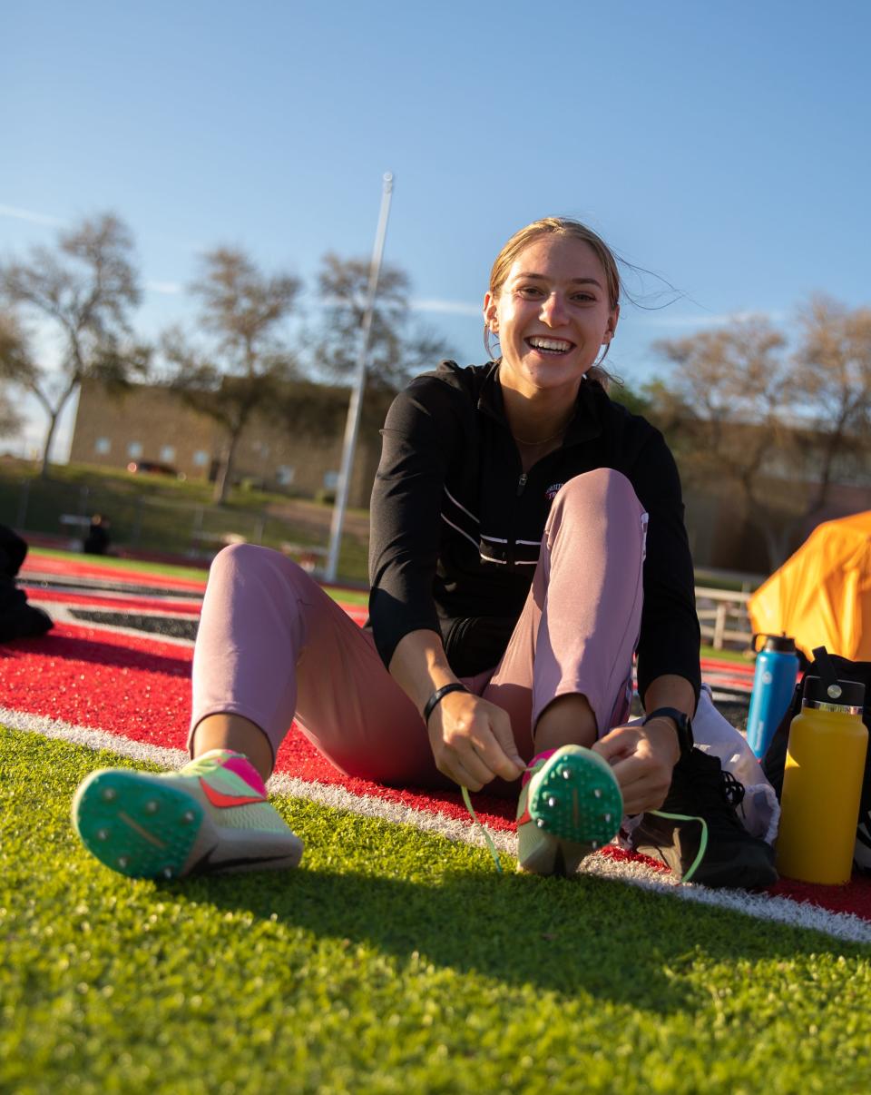 Makenna Topp switches shoes during a 3-way track meet on the Boulder Creek High School track in Anthem on March 29, 2023.