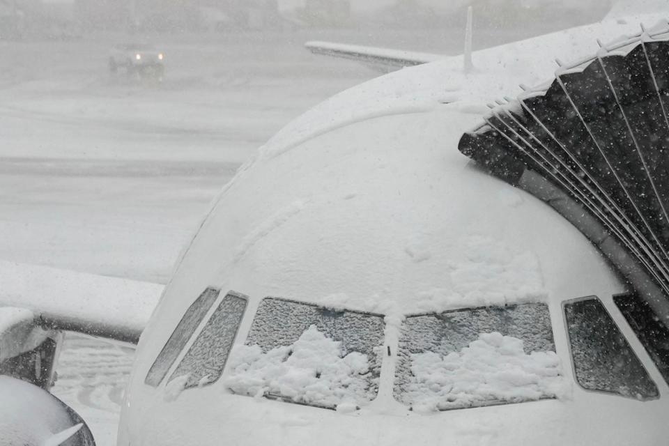 Snow covers the windows of a plane that sits at a gate in JFK (Copyright 2024 The Associated Press. All rights reserved.)