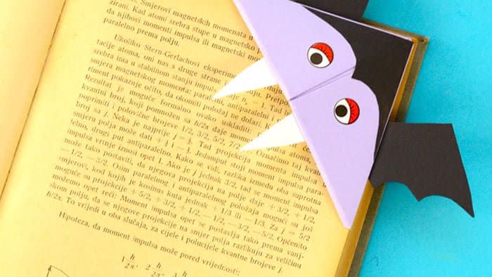 paper vampire bookmark crafted for halloween activity placed on the corner of a book page