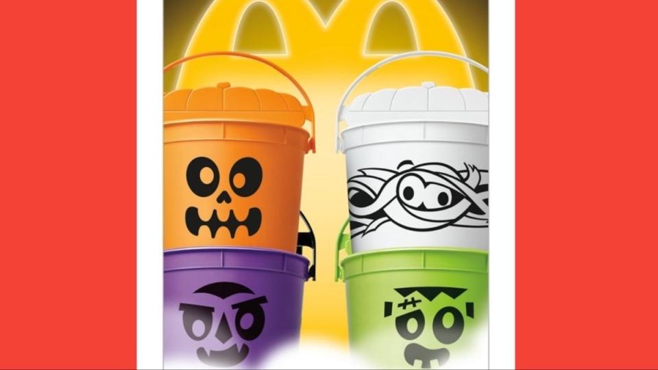 Four different colored McDonald's Boo Buckets on display together with the Golden Arches behind them