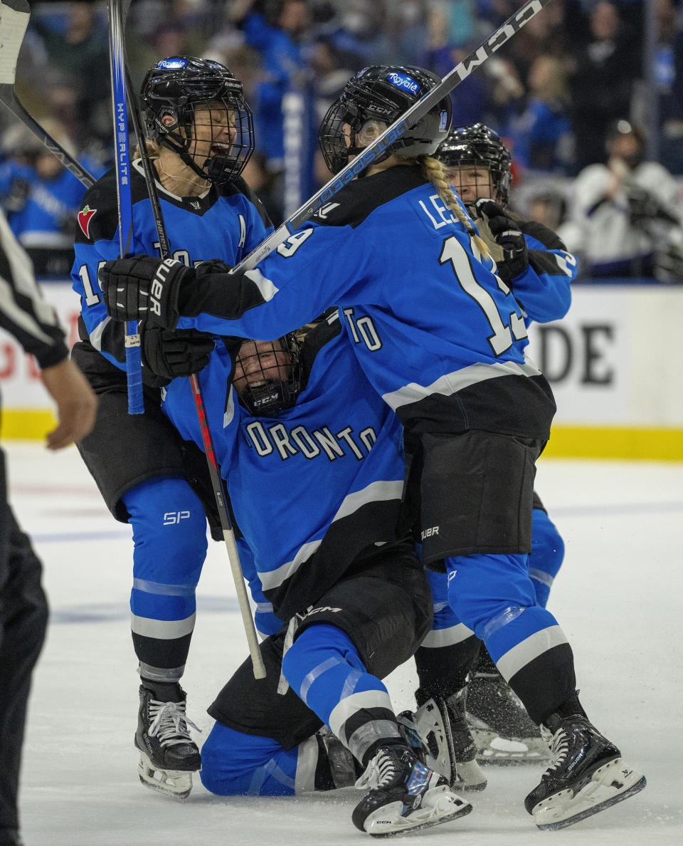 Toronto's Emma Maltais, bottom, celebrates with Rebecca Leslie, right, and Renata Fast, left, after the winning goal against Minnesota in third-period PWHL hockey playoff action in Toronto, Friday, May 10, 2024. (Frank Gunn/The Canadian Press via AP)