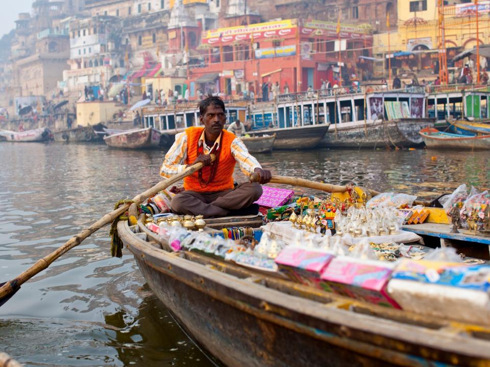 A man sells souvenirs from his boat beside Varanasi in 2012.