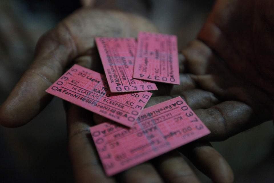 In this Photo taken, Friday, March . 8, 2013, a man displays train tickets to Kano, in Lagos, Nigeria. Nigeria reopened its train line to the north Dec. 21, marking the end of a $166 million project to rebuild portions of the abandoned line washed out years earlier. The state-owned China Civil Engineering Construction Corp. rebuilt the southern portion of the line, while a Nigerian company handled the rest. The rebirth of the lines constitutes a major economic relief to the poor who want to travel in a country where most earn less than $1 a day. Airline tickets remain out of the reach of many and journeys over the nation's crumbling road network can be dangerous. The cheapest train ticket available costs only $13. ( AP Photo/Sunday Alamba)