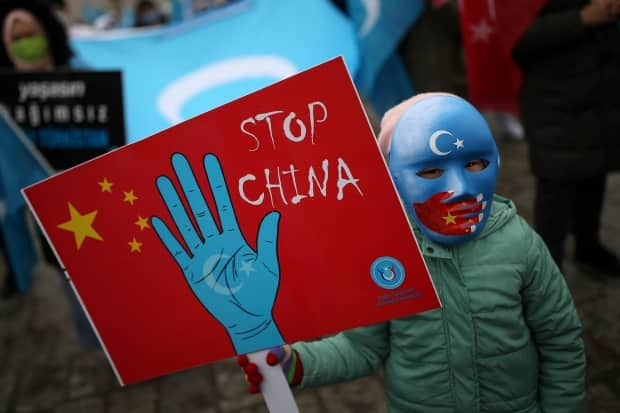 A protester from the Uyghur community living in Turkey holds an anti-China placard during a protest in Istanbul on Thursday, March 25.