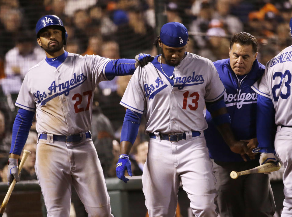 Los Angeles Dodgers' Hanley Ramirez, center, walks off the field as teammate Matt Kemp (27) gives him a pat on the shoulder after Ramirez was hit by a throw from San Francisco Giants' Ryan Vogelsong during the seventh inning of a baseball game on Wednesday, April 16, 2014, in San Francisco. (AP Photo/Marcio Jose Sanchez)