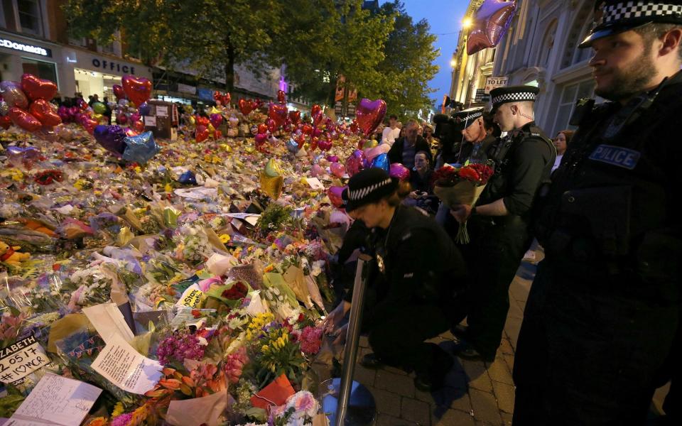  Police officers pay their respects for the victims of the Manchester bombing - Credit: Nigel Roddis /EPA