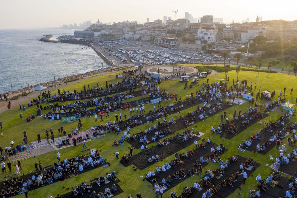 Muslim worshippers offer Eid al-Adha prayer at a park as mosques are limited for ten people following the government's measures to help stop the spread of the coronavirus, in the mixed Arab Jewish city of Jaffa, near Tel Aviv, Israel, Friday, July 31, 2020. (AP Photo/Oded Balilty)
