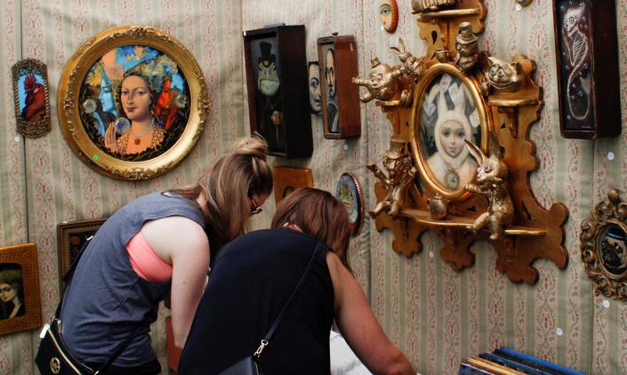 Visitors check out an artist's booth at Art in the Park 2018.