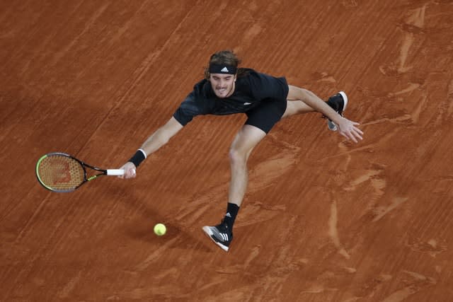 Stefanos Tsitsipas stretches for a forehand against Novak Djokovic