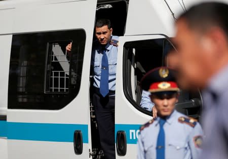 Law enforcement officers stand guard during an anti-government protest in Almaty