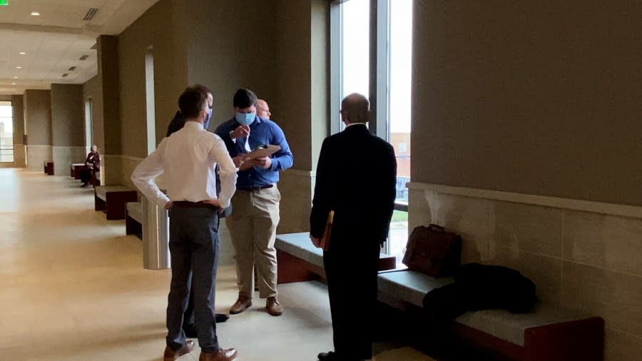 Former Marlboro County Sheriff’s Deputy Andrew Cook signs a form as he huddles with his legal team before a Dec. 21, 2021, arraignment in Florence County. Cook and Sheriff Charles Lemon were charged with one count of misconduct in office and assault and battery of a high and aggravated nature. (WJZY Photo/Jody Barr)