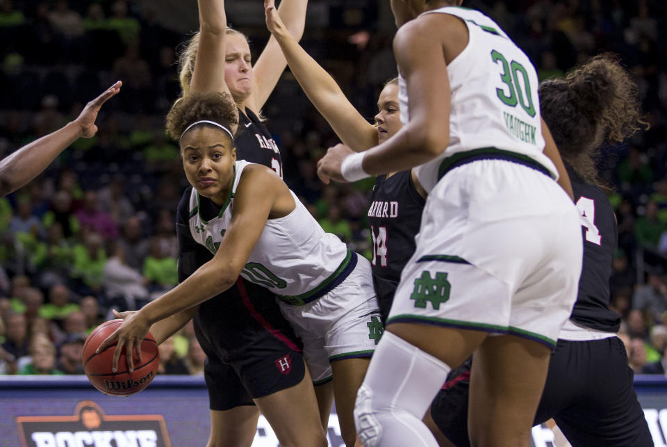 Notre Dame's Katlyn Gilbert, center, looks to pass as she gets pressure from Harvard's Maddie Stuhlreyer, left, and Mackenzie Barta (14) during the second half of an NCAA college basketball game Friday, Nov. 9, 2018, in South Bend, Ind. Notre Dame won 103-58. (AP Photo/Robert Franklin)