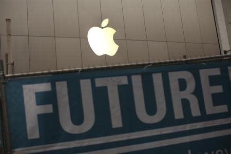 The Apple logo is pictured on the front of the company's flagship retail store near signs for the central subway project in San Francisco, California January 23, 2013. REUTERS/Robert Galbraith