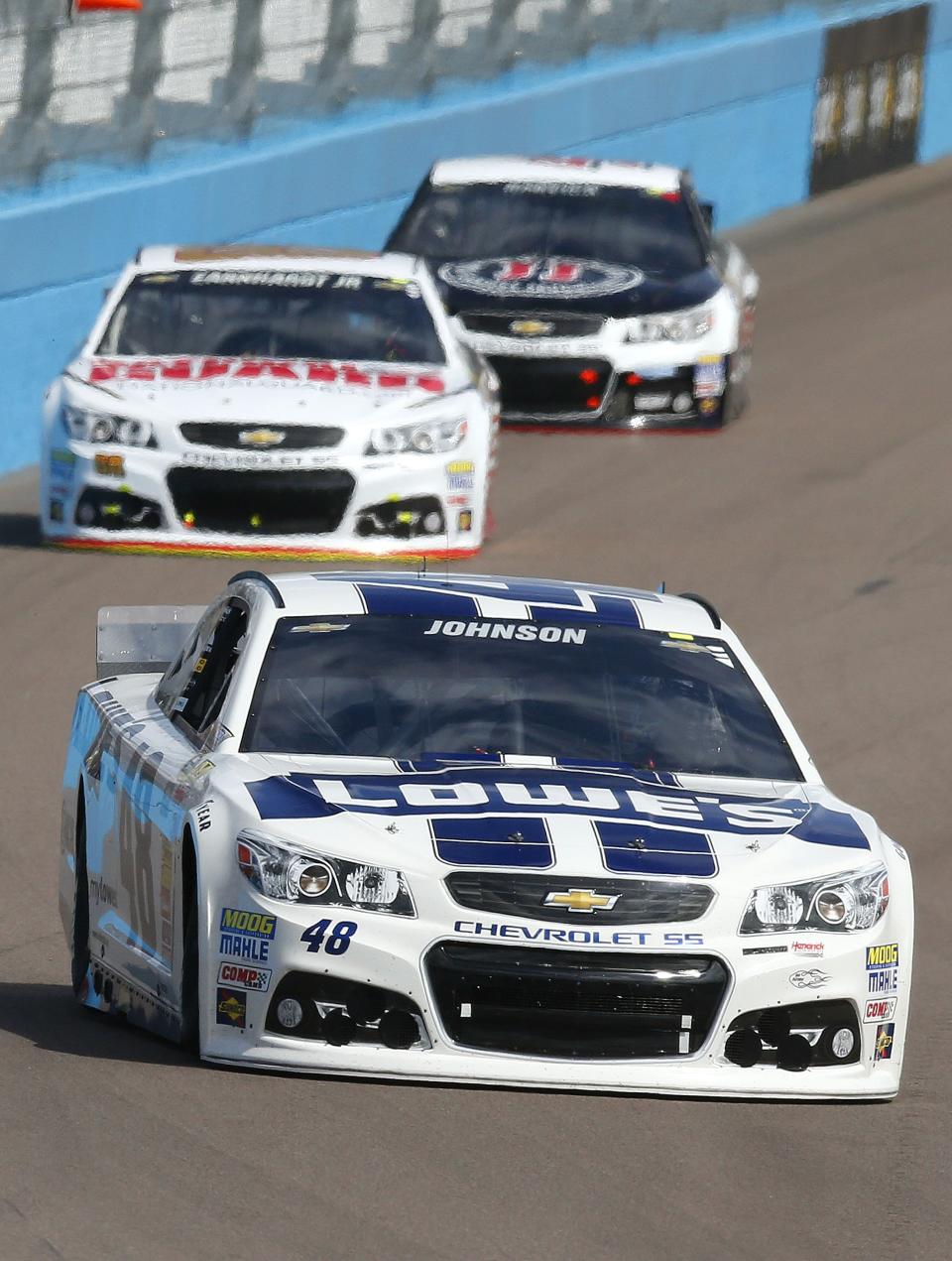 Jimmie Johnson (48), Dale Earnhardt, Jr., back left, and Kevin Harvick head into Turn 1 during the NASCAR Sprint Cup Series auto race Sunday, March 2, 2014, in Avondale, Ariz. (AP Photo/Ross D. Franklin)