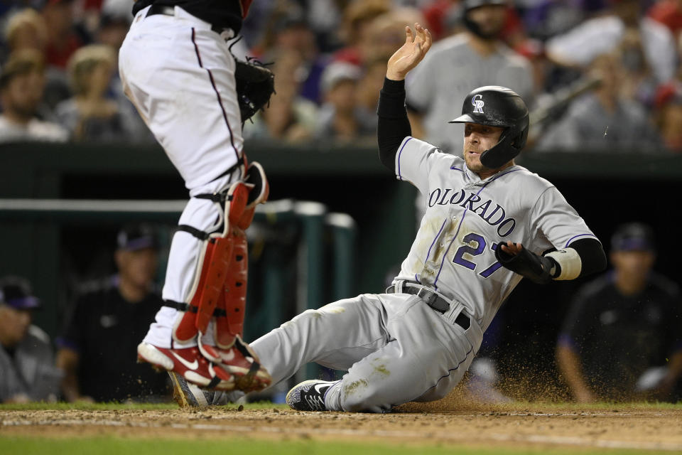 Colorado Rockies' Trevor Story (27) slides home to score on a single by Ryan McMahon during the sixth inning of a baseball game against the Washington Nationals, Friday, Sept. 17, 2021, in Washington. (AP Photo/Nick Wass)