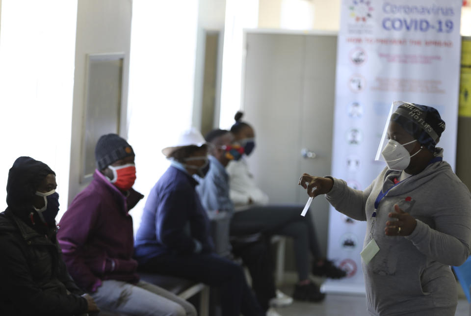 FILE - In this Wednesday, June 24, 2020 file photo, a medical worker addresses some of the first vaccine volunteers, at the Chris Hani Baragwanath hospital in Soweto, Johannesburg. Refrigeration, cargo planes, and, above all, money: All risk being in short supply for the international initiative to get coronavirus vaccines to the world’s most vulnerable people. (AP Photo/Siphiwe Sibeko, File)