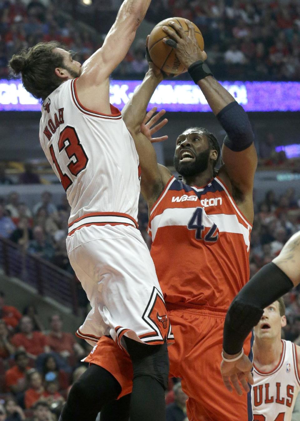Washington Wizards forward Nene, right, drives to the basket against Chicago Bulls center Joakim Noah during the first half in Game 1 of an opening-round NBA basketball playoff series in Chicago, Sunday, April 20, 2014. (AP Photo/Nam Y. Huh)