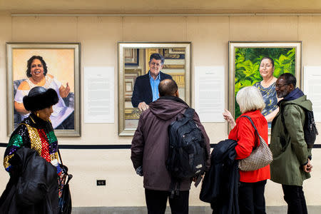 Visitors examine Betsy Ashton's exhibition, "Portraits of Immigrants: Unknown Faces, Untold Stories" at Riverside Church in New York, U.S., March 10, 2019. REUTERS/Demetrius Freeman