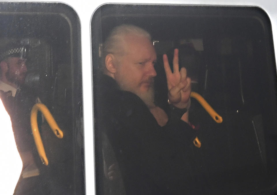 Julian Assange hace señas a su llegada al Tribunal de Magistrados de Westminster, en Londres, después de que agentes lo sacaran de la embajada ecuatoriana y lo arrestaran, el jueves 11 de abril de 2019. (Victoria Jones/PA vía AP)