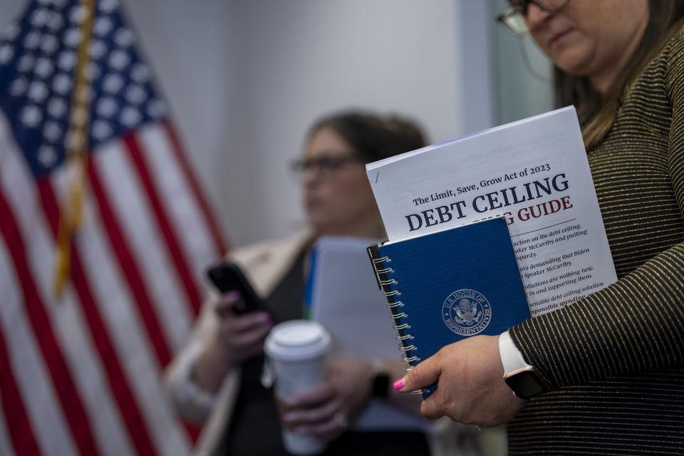 A staffer with the Republican leadership holds a guide to Speaker Kevin McCarthy's debt ceiling package during a news conference at the Capitol in Washington, Wednesday, April 26, 2023. McCarthy is struggling to round up the votes for the bill, which would couple an increase of the country's debt ceiling with restrictions on federal spending. A final vote on the package is likely Thursday. (AP Photo/J. Scott Applewhite)