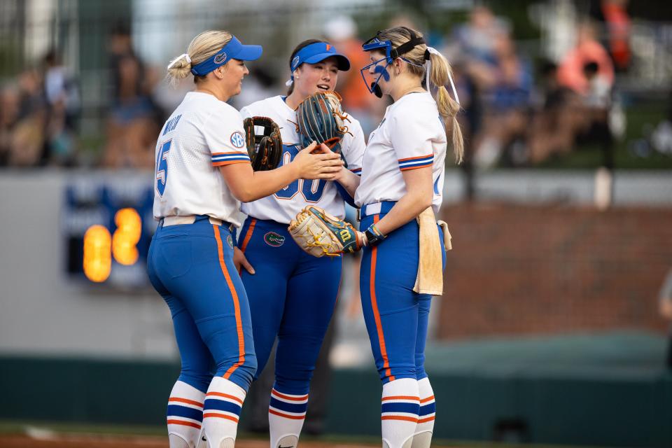 Florida Gators infielder Reagan Walsh (15), Florida Gators first baseman Ava Brown (00) and Florida Gators pitcher Keagan Rothrock (7) talk in between innings against the LSU Tigers during the game at Katie Seashole Pressly Stadium at the University of Florida in Gainesville, FL on Monday, April 8, 2024. [Matt Pendleton/Gainesville Sun]