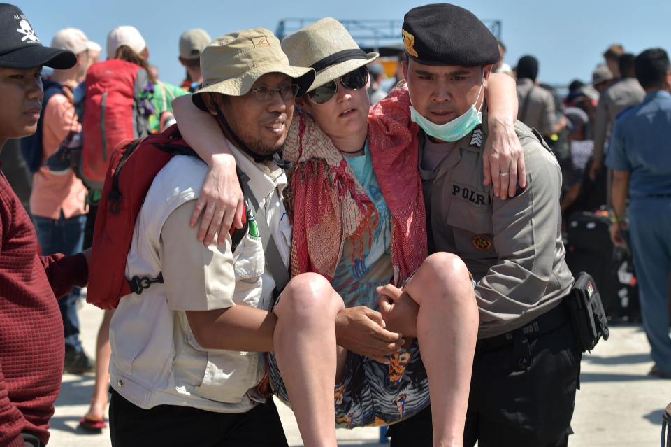 <p>A foreign tourist (C) is given assistance as evacuated tourists arrive from nearby Gili Trawangan island at the port at Bangsal in northern Lombok on Aug. 7, 2018, two days after the area was struck by an earthquake. (Photo: Adek Berry/AFP/Getty Images) </p>