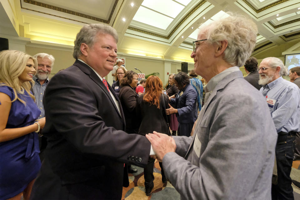 Attorney General Jim Hood, left, shakes hands a with supporter as they await election results from the gubernatorial race against Republican candidate Tate Reeves, Tuesday, Nov. 5, 2019, at the Hilton Garden Inn in Jackson, Miss. (AP Photo/Charles A. Smith)