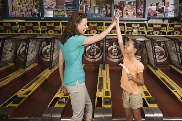 A mother and daughter playing arcade games.