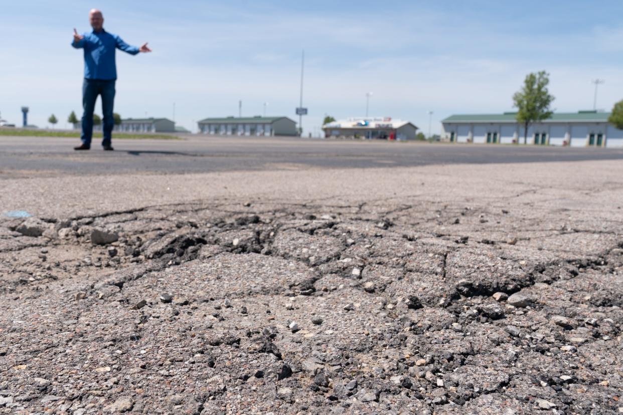 Asphalt within a large pit parking lot in dire need of resurfacing is shown by Heartland Motorsports Park owner Chris Payne Wednesday as he tours some of the deferred maintenance he sees around the property.