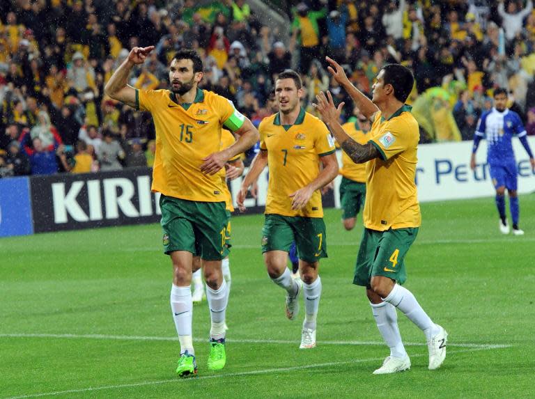 Australia's Mile Jedinak (L) celebrates with teammates Matthew Leckie (C) and Tim Cahill after scoring during their Asian Cup match against Kuwait in Melbourne on January 9, 2015