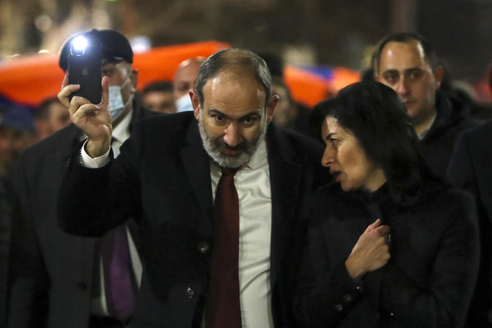 Armenian Prime Minister Nikol Pashinyan and his wife Anna Akobyan walk with supporters during a rally in his support in the center of Yerevan, Armenia, Monday, March 1, 2021. Amid escalating political tensions in Armenia, supporters of the country's embattled prime minister and the opposition are staging massive rival rallies in the capital of Yerevan. Prime Minister Nikol Pashinyan has faced opposition demands to resign since he signed a peace deal in November that ended six weeks of intense fighting with Azerbaijan over the Nagorno-Karabakh region. (Hayk Baghdasaryan/PHOTOLURE via AP)