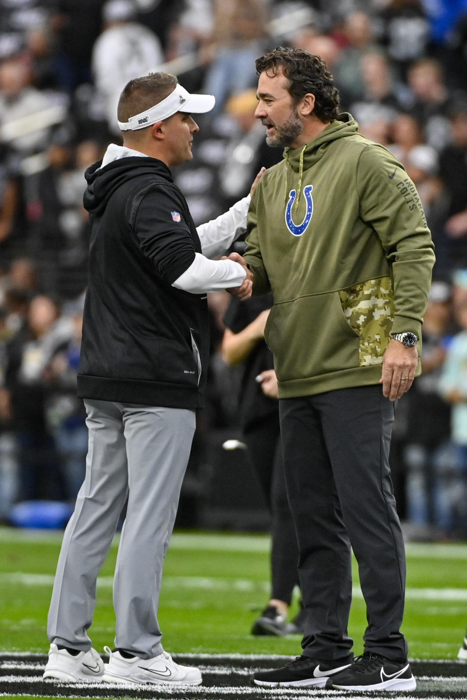 Indianapolis Colts interim head coach Jeff Saturday, right, meets with Las Vegas Raiders head coach Josh McDaniels before an NFL football game in Las Vegas, Sunday, Nov. 13, 2022. (AP Photo/David Becker)