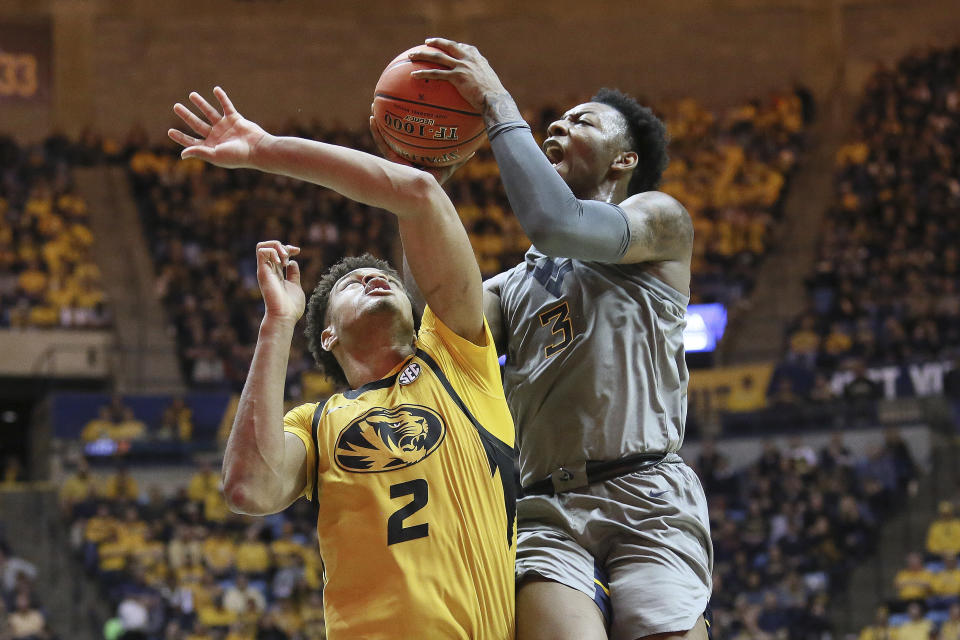 West Virginia forward Gabe Osabuohien (3) goes to make a shot as he is defended by Missouri forward Tray Jackson (2) during the second half of an NCAA college basketball game Saturday, Jan. 25, 2020, in Morgantown, W.Va. (AP Photo/Kathleen Batten)