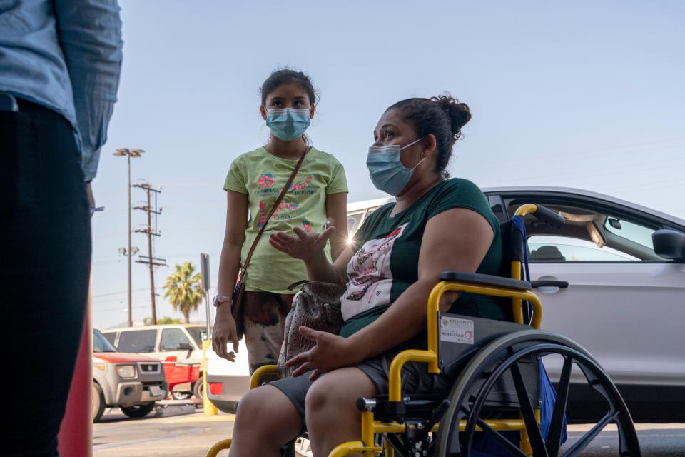 Edia Cordero and her daughter Jasmin, 11, talk with community organizers outside a Target store in Pacoima last week. Cordero, who is unvaccinated, says she would get her daughter vaccinated if Los Angeles schools require it. “As a mom, I’d do anything to protect my daughter, and if that means getting the vaccine, I’ll do it.”