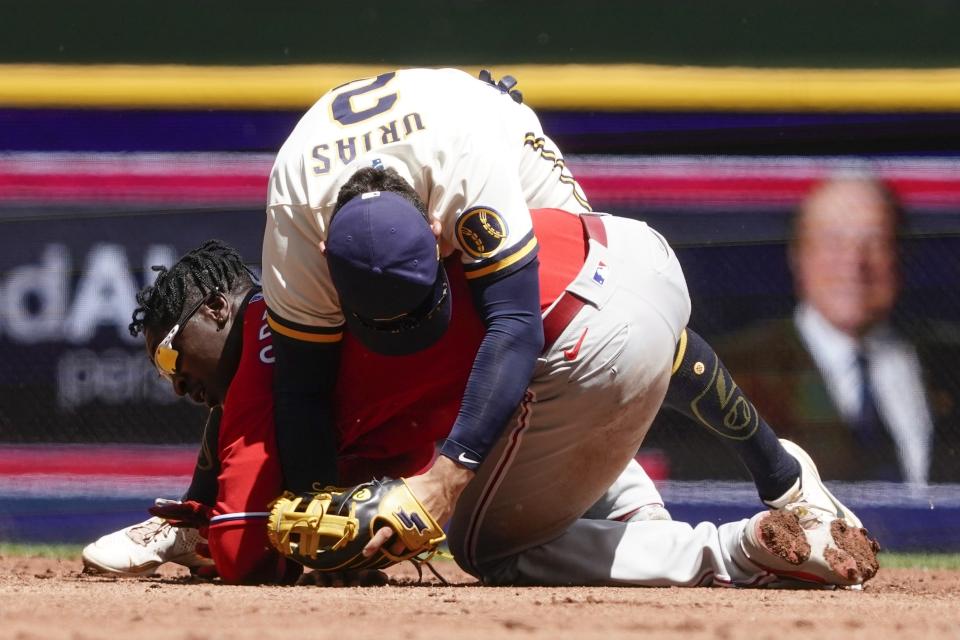 Milwaukee Brewers' Luis Urias gets tangled with Philadelphia Phillies' Didi Gregorius during the second inning of a baseball game Thursday, June 9, 2022, in Milwaukee. Gregorius broke up a double play on a ball hit by Bryson Stott. (AP Photo/Morry Gash)