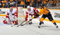 NASHVILLE, TN - APRIL 13: Martin Erat #10 of the Nashville Predators passes the puck in front of Brad Stuart #23 and goalie Jimmy Howard #35 of the Detroit Red Wings in Game Two of the Western Conference Quarterfinals during the 2012 NHL Stanley Cup Playoffs at the Bridgestone Arena on April 13, 2012 in Nashville, Tennessee. (Photo by Frederick Breedon/Getty Images)