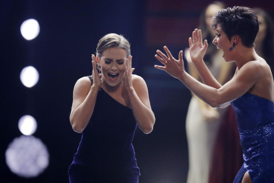 Camille Schrier, of Virginia, left, reacts after winning the Miss America competition at the Mohegan Sun casino in Uncasville, Conn., Thursday, Dec. 19, 2019. At right is runner-up Miss. Georgia Victoria Hill. (AP Photo/Charles Krupa)